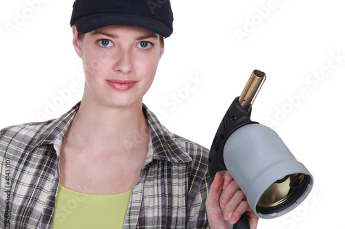 Blond welder holding blow torch