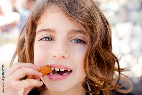 Blue eyes little girl eating churros fried crullers