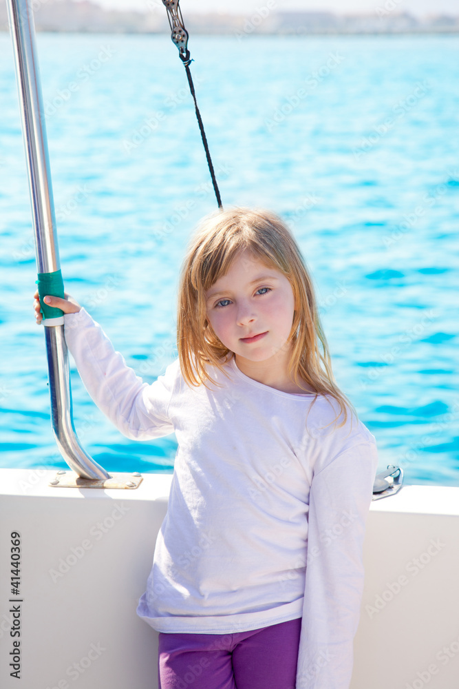 blond little kid girl sailing in a boat smiling