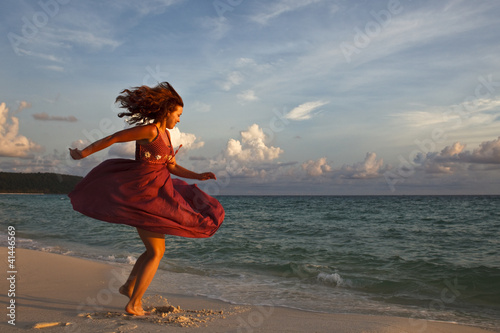 Девушка танцует на пляже