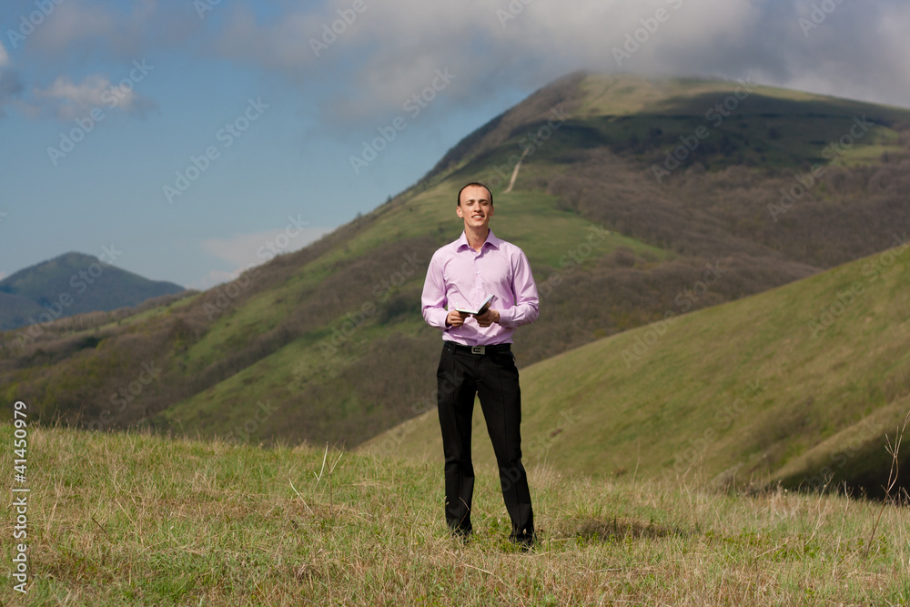 man with book on mountain