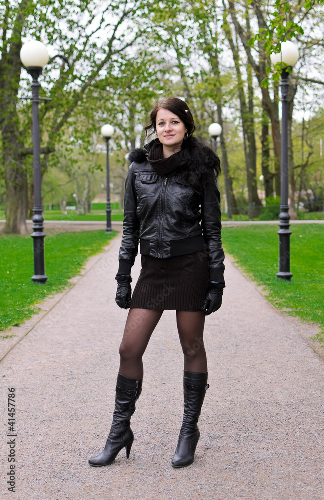 Attractive girl girl in a jacket on the road in the park