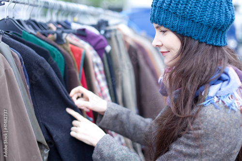 Woman choosing clothes at the flea market.