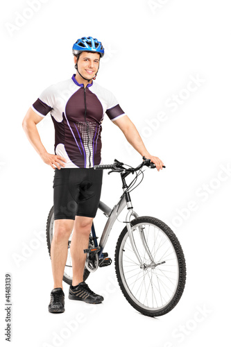Full length portrait of a young bicyclist posing next to a bicyc