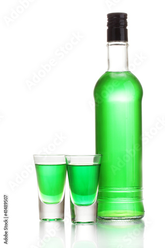bottle and two glasses of absinthe isolated on white