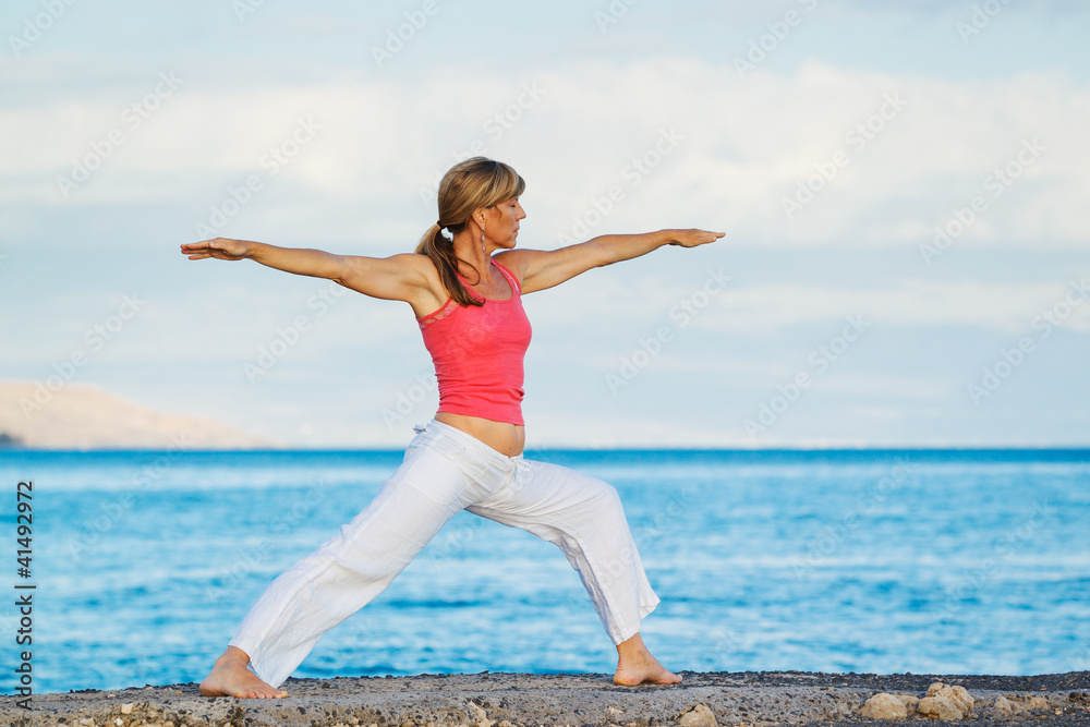 Beautiful Yoga woman Practicing Yoga by the Ocean Beautiful Yoga woman Practicing Yoga by the Ocean