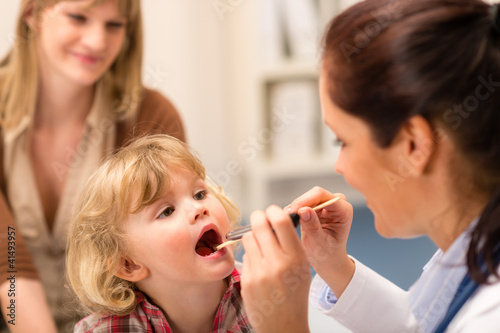 Pediatrician examine child throat look with light