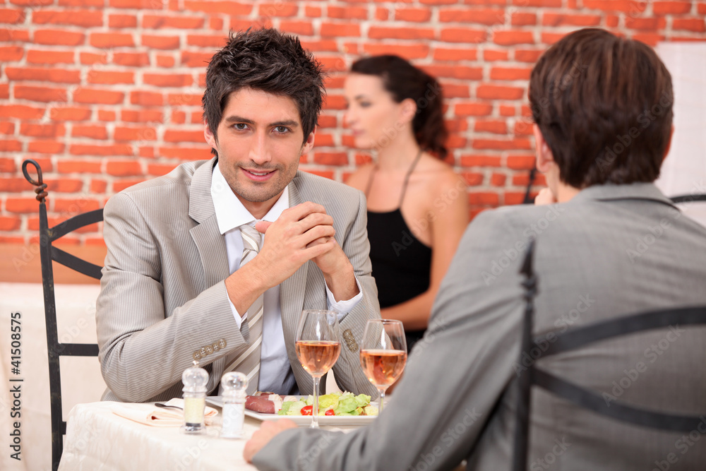 two businessmen eating in a restaurant two businessmen eating in a restaurant