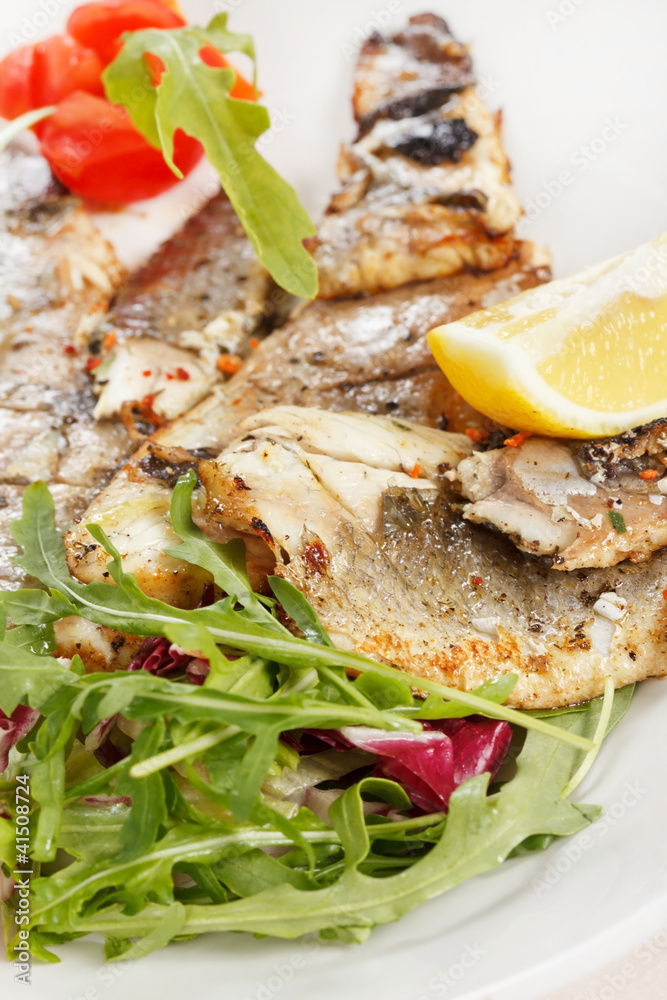 Grilled fish fillet with tomato and lemon