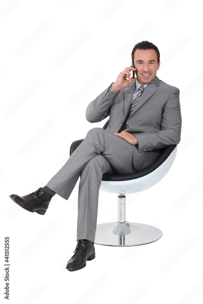 Executive in a swivel chair talking on a cellphone Executive in a swivel chair talking on a cellphone