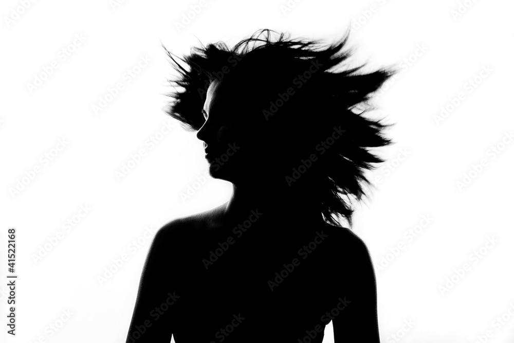 Silhouette of beautiful girl spinning her head with flying hair