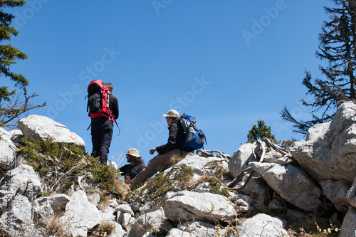 three mountaineers resting on the top of the hill