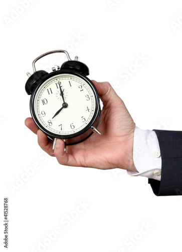 Alarm clock in a man's hand on a light background