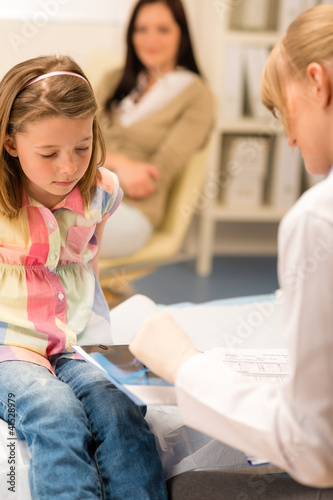 At pediatrician office girl look medical document