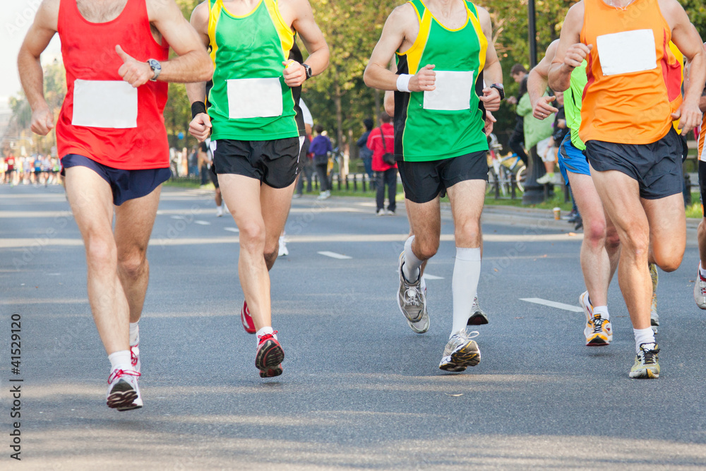 Runners running in city marathon on street Runners running in city marathon on street