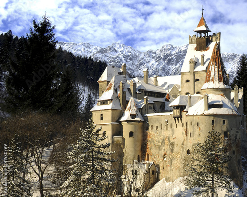 Dracula's Bran Castle in winter with snow and mountains. (2 superimposed images)