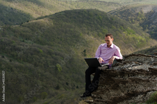 man with notebook on stone