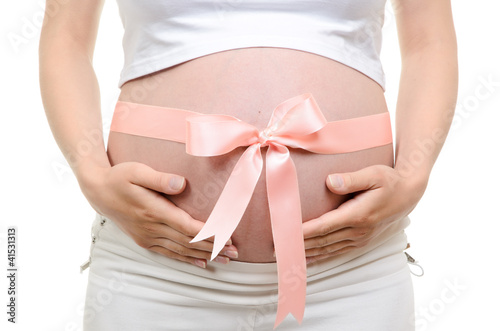 Pregnant belly with pink ribbon © ashumskiy