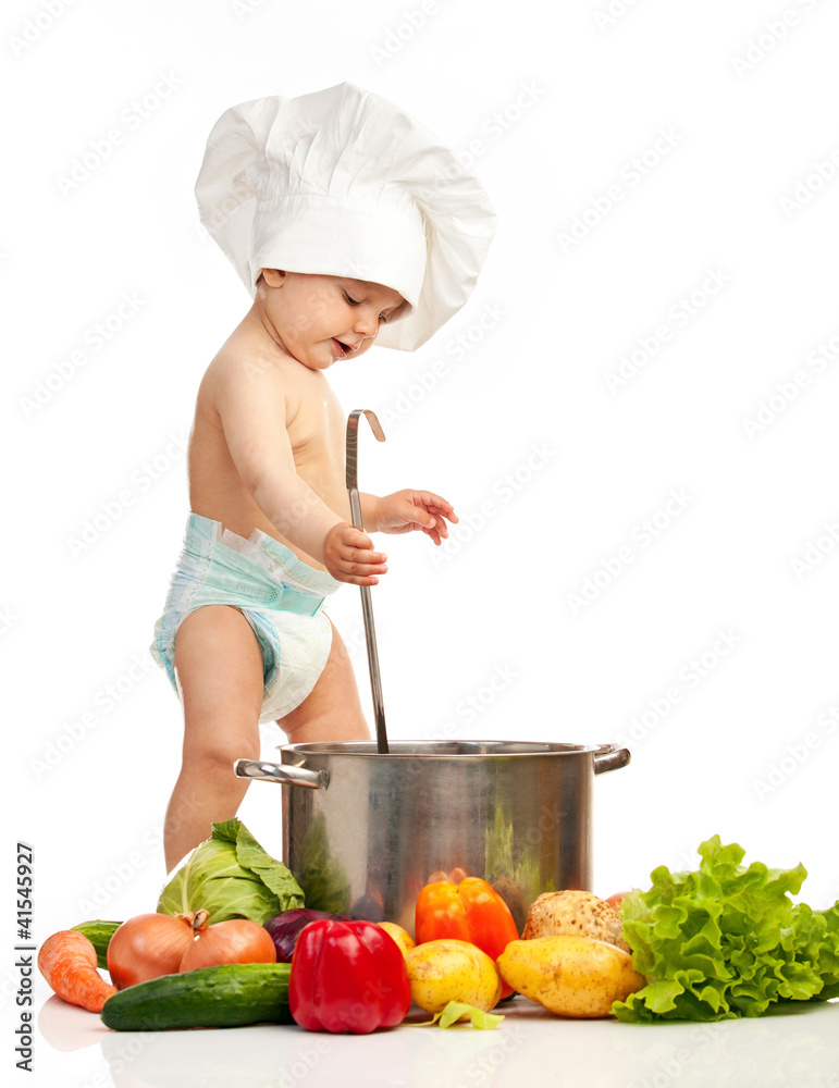 Little boy in chef's hat with ladle, casserole, and vegetables Little boy in chef's hat with ladle, casserole, and vegetables