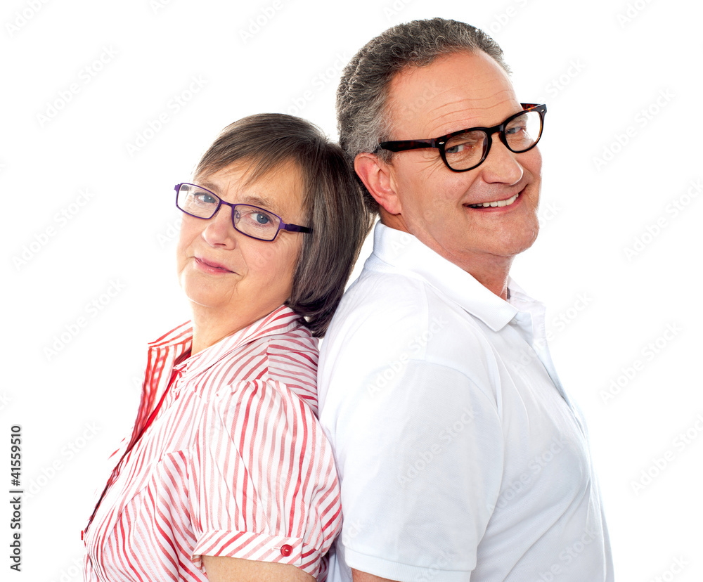 Portrait of smiling aged couple posing back to back Portrait of smiling aged couple posing back to back