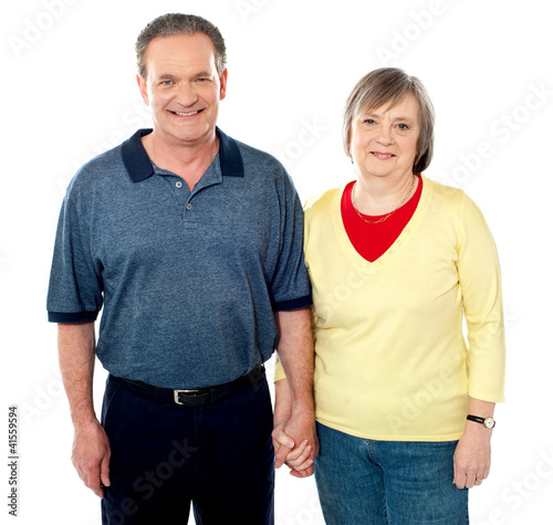 Loving senior couple posing with hand in hand