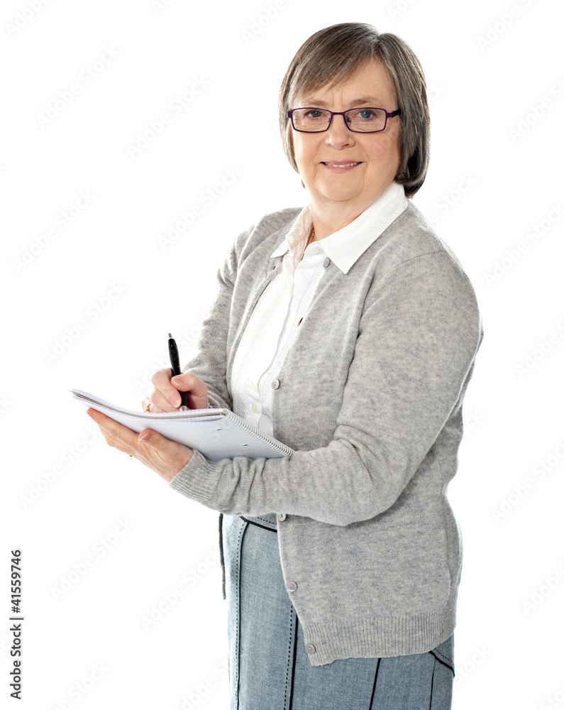 Aged woman writing on spiral notebook Aged woman writing on spiral notebook