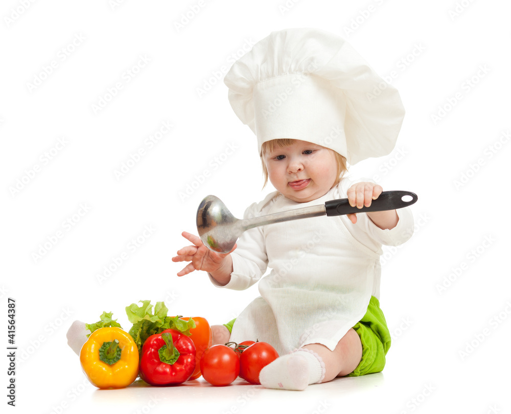 Kid in chef hat with healthy food vegetables Kid in chef hat with healthy food vegetables