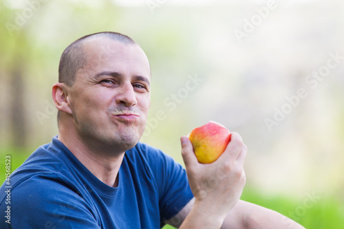 Man eating an apple outdoor
