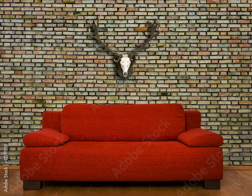 Rote Couch vor Backsteinwand