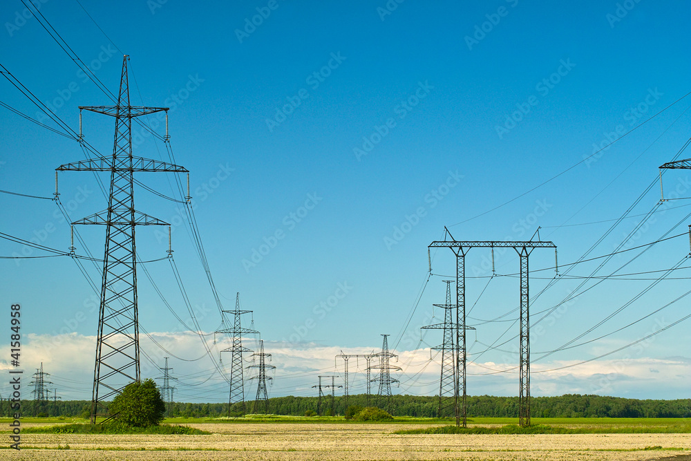 Power line towers and wires, yellow autumn field and sky