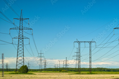 Power line towers and wires, yellow autumn field and sky