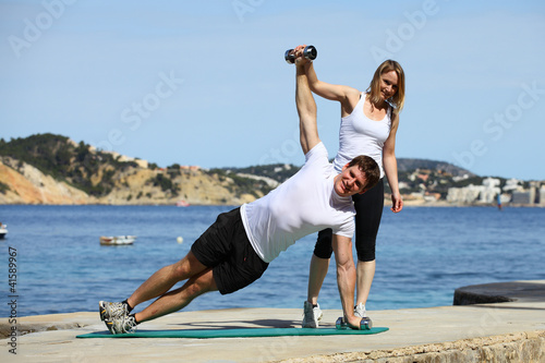 trainierin zeigt übungen am strand photo