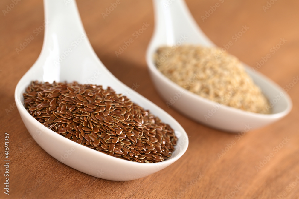 Brown flax seeds and sesame on ceramic spoon