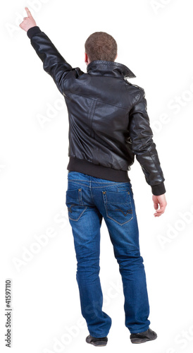 Back view of man in jacket pointing.