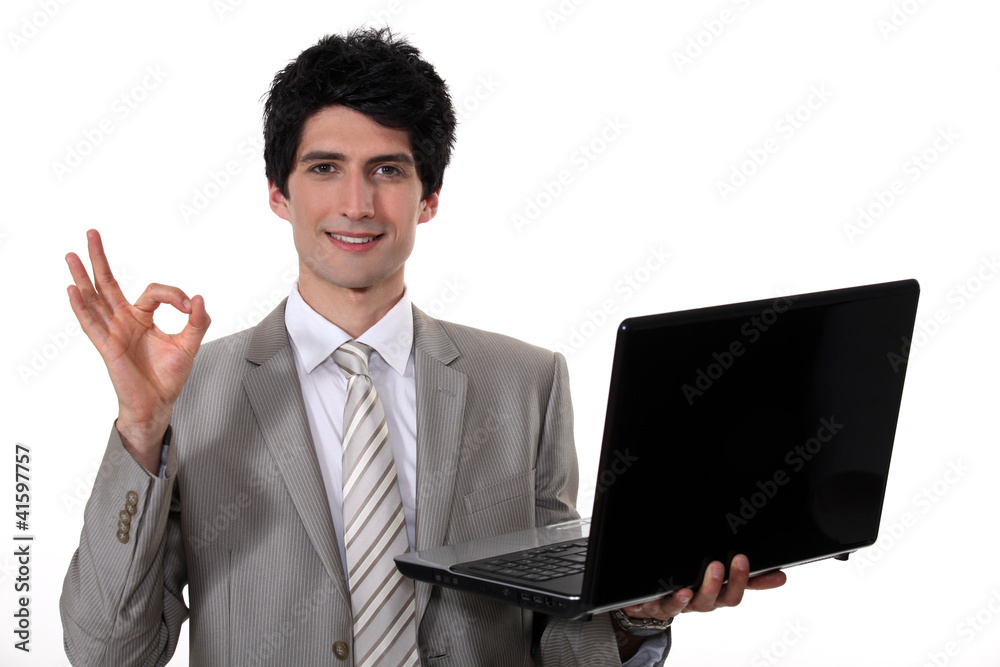 young handsome businessman with laptop making okay sign young handsome businessman with laptop making okay sign