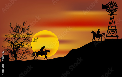 two cowboys at orange sunset