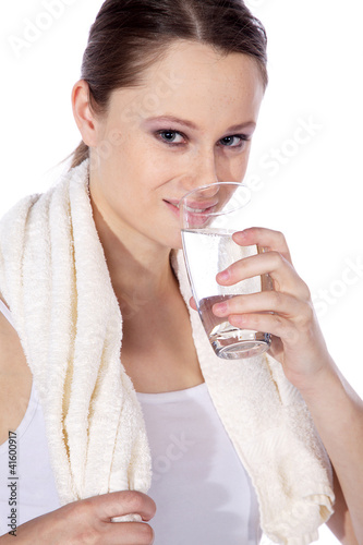 Sportliche Frau trinkt Wasser lächelt Porträt