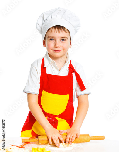 Beautiful caucasian boy making a cake photo