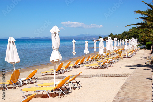 Sunbeds on a beach and turquoise water at the modern luxury hote photo