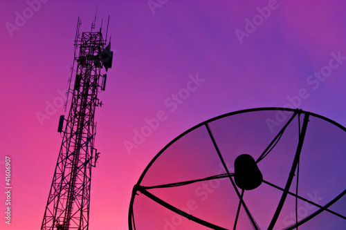 Satellite dish and communication tower at sunset