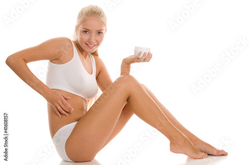 Photos Woman applying body lotion