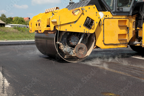 Roadwork road roller at hot asphalt
