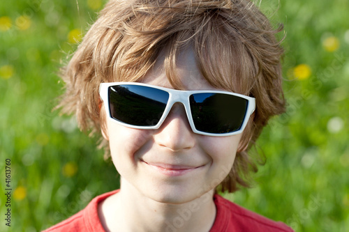 Blonde naughty little boy wearing sunglasses