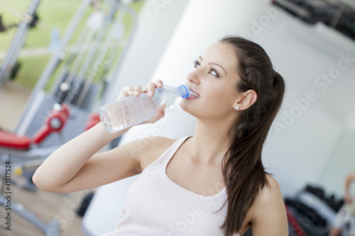 Girl drinking water in the gym