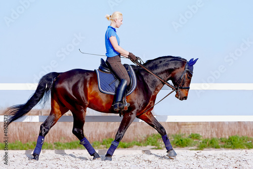 Bild auf Leinwand The girl goes on a brown horse