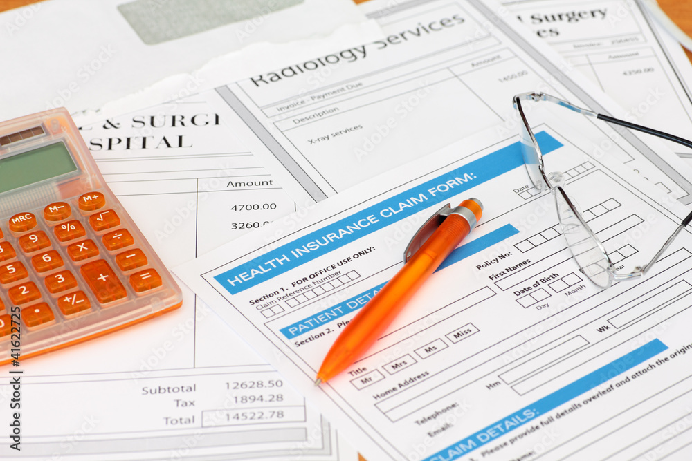 Surgery bills with health insurance claim calculator and pen Surgery bills with health insurance claim calculator and pen