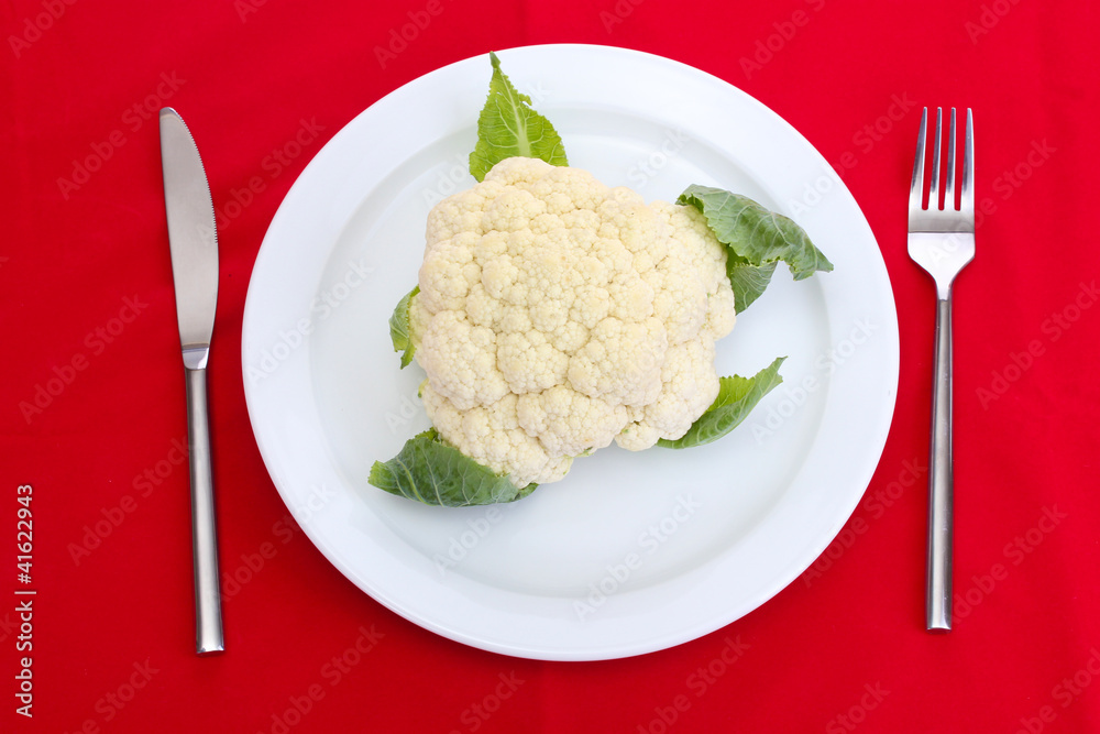 Fresh cauliflower on plate, knife and fork Fresh cauliflower on plate, knife and fork