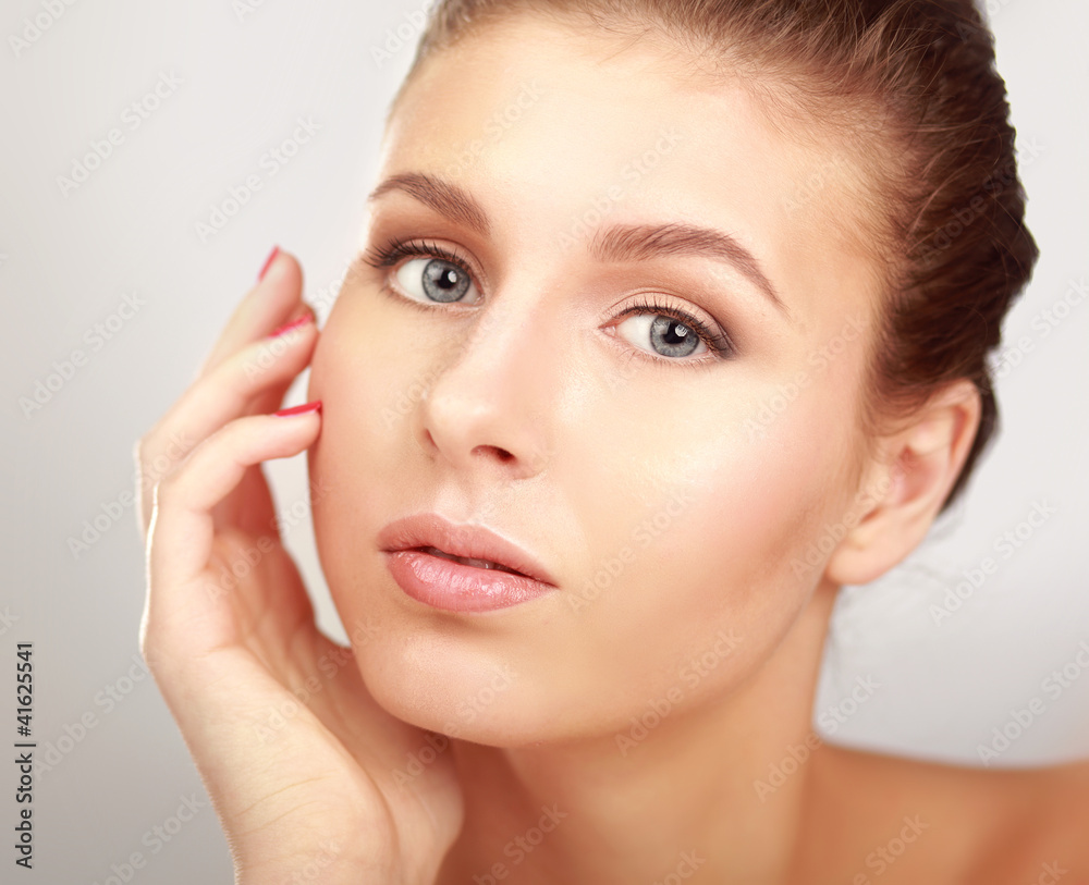 Fototapeta premium Piękna młoda kobieta dotyka jej twarzy