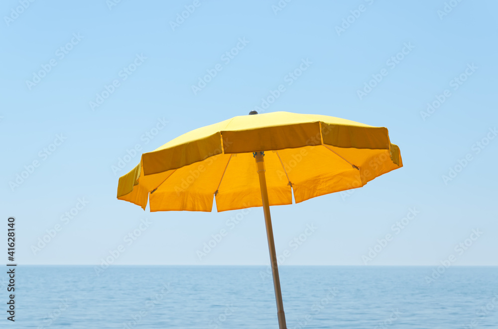 yellow umbrella over sea under blue sky