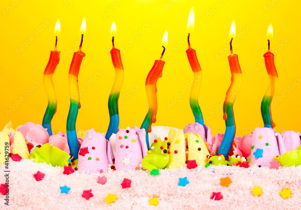 Birthday cake with candles on yellow background Birthday cake with candles on yellow background